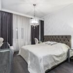 Spacious modern bedroom featuring a plush bed and elegant lighting, perfect for relaxation.