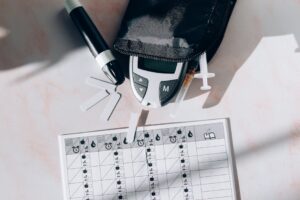 Image of a diabetes management kit including a glucometer, syringes, and monitoring chart.