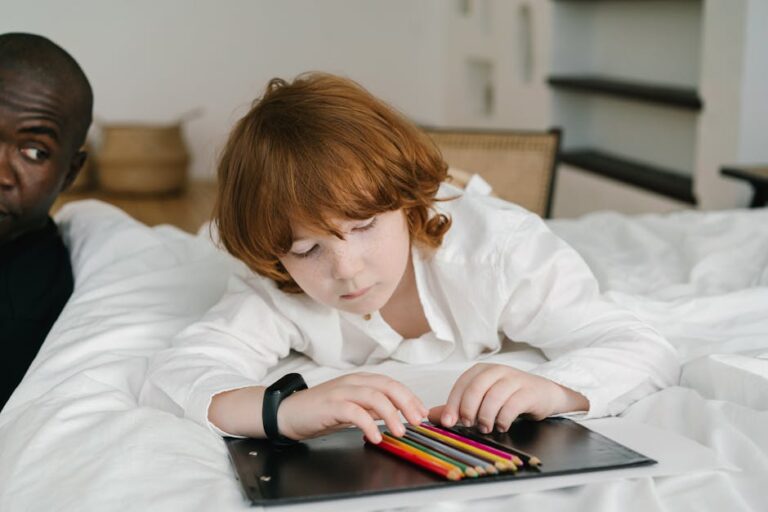 Red-haired child engaged in coloring with pencils on a bed indoors.
