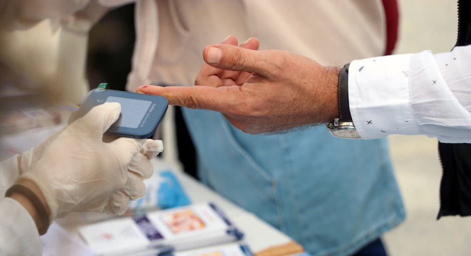 A healthcare professional checks blood glucose at a public event.