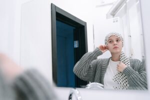 Young woman wearing polka dot headscarf, reflecting on her image in a modern bathroom mirror.