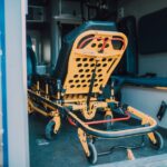 A detailed view of a yellow emergency stretcher inside an ambulance, ready for use.