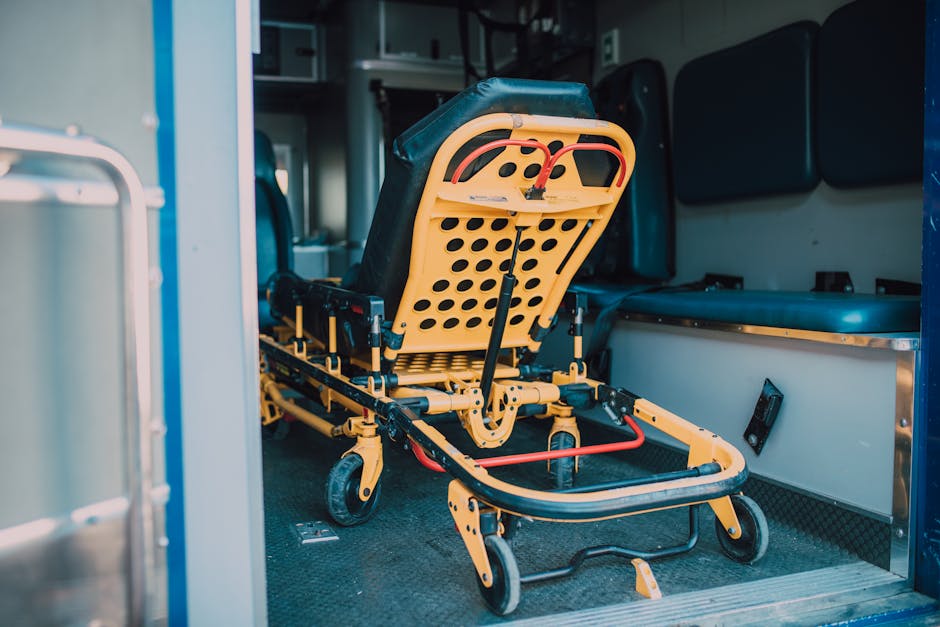 A detailed view of a yellow emergency stretcher inside an ambulance, ready for use.
