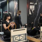 Women engaging in pilates exercises on reformers at a contemporary gym.
