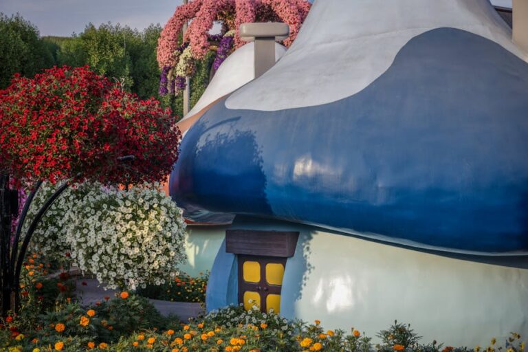 Charming mushroom house surrounded by colorful blooming flowers in a vibrant garden setting.