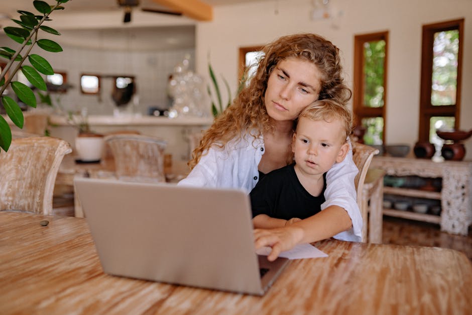 Mother and child using a laptop at home, working and bonding in a cozy environment.