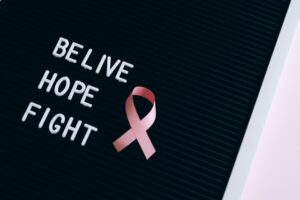 Inspirational breast cancer awareness message on a letter board with a pink ribbon.