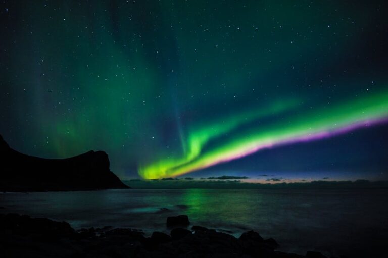 Breathtaking display of Northern Lights over the sea at Myrland, Norway.